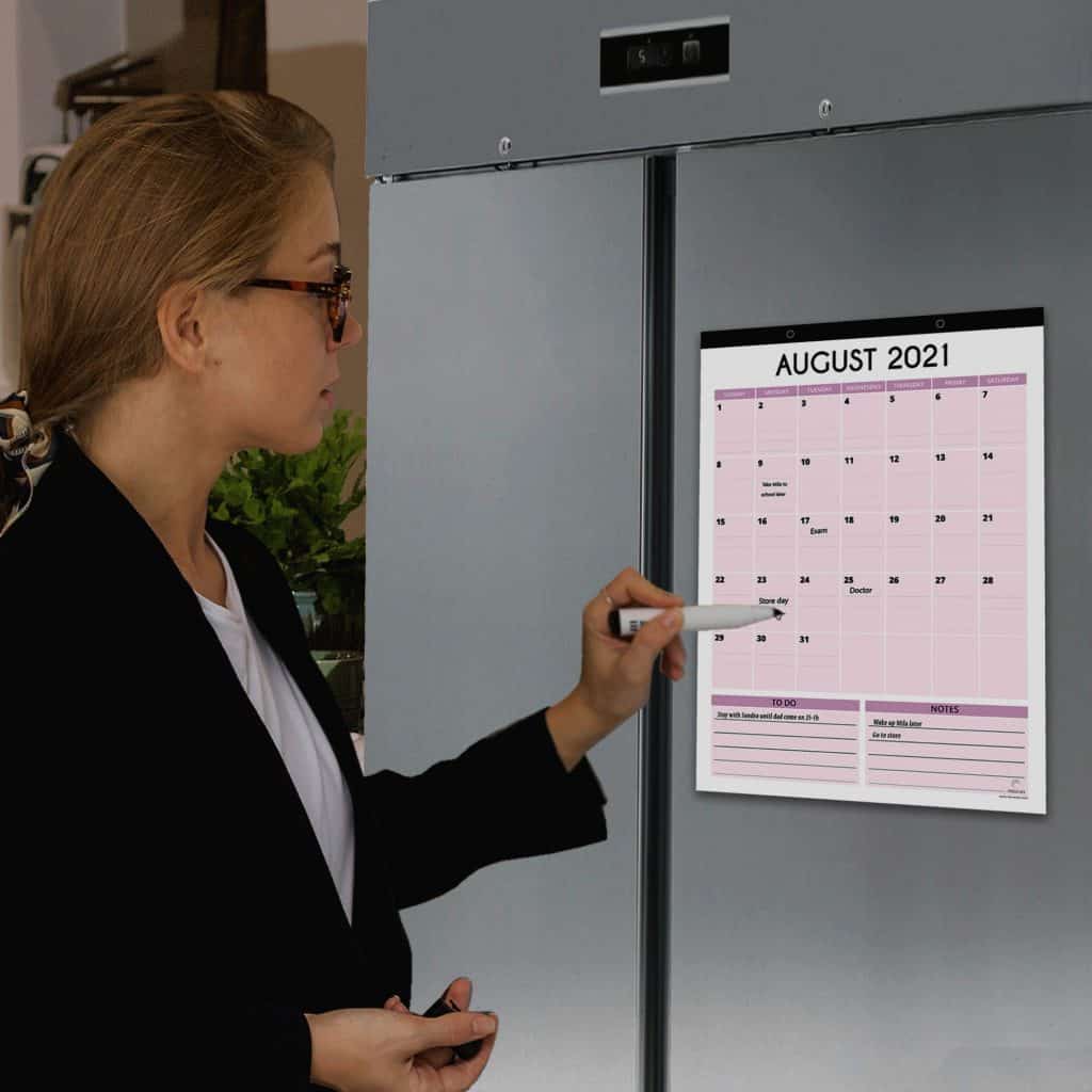 woman writing on her vertical style magnetic fridge calendar