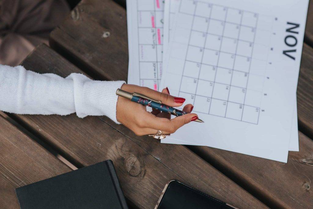 Girl Writing using a paper calendar
